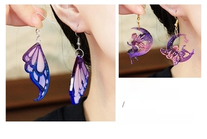 Detailed view of butterfly and moon fairy resin earrings with glitter and purple gradient