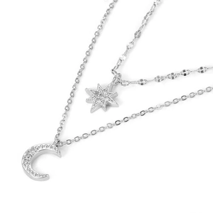 Close-up of double-layer silver necklace featuring sparkling star and moon pendants