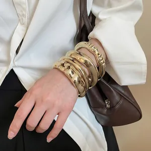 Ensemble de quatre bracelets géométriques dorés superposés, polis et texturés