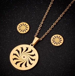 Détail d'un ensemble de bijoux dorés avec pendentif tourbillon évidé et boucles d'oreilles