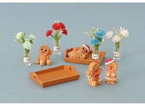 Miniature gingerbread men figurines with small flower vases on brown wooden trays