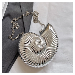 Detailed view of silver snail-shaped evening clutch with glossy metallic spiral texture