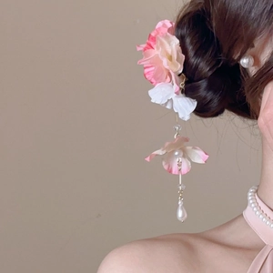 Détail d'une pince à cheveux fleurie avec pétales en soie, perles et longs glands