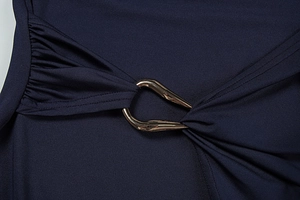Macro detail of navy blue dress featuring elegant side ruching and a matte gold metal hook