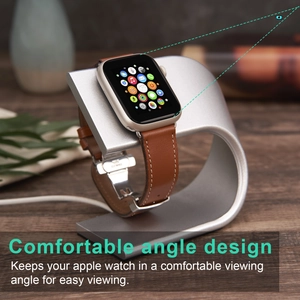 Silver aluminum U-shaped charging stand for Apple Watch with brown leather strap on a desk
