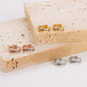 Three pairs of crisscross earrings in gold, rose gold, and silver with inlaid cubic zirconia
