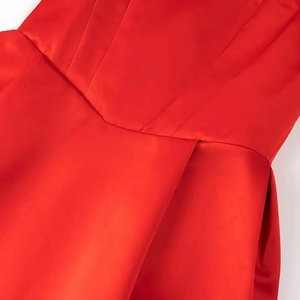Detailed view of red satin dress with elegant V-shaped waist and pleated fabric texture