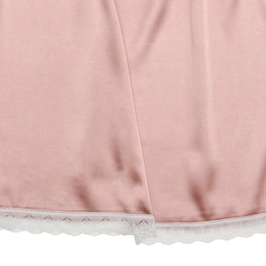 Vue détaillée de l'ourlet de jupe en satin rose avec bordure en dentelle blanche délicate