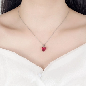 Elegant silver necklace with red heart-shaped zircon pendant worn by model