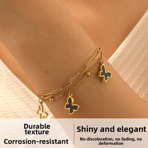 Close-up of a double-layer gold stainless steel bracelet with black butterfly charms