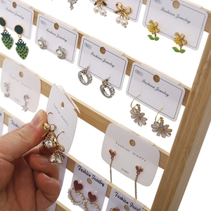 Bamboo jewelry stand displaying various S925 silver needle earrings on white cards