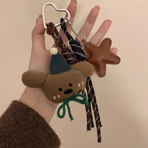 Dettaglio portachiavi orsetto di peluche con stella in pelle e cordino intrecciato