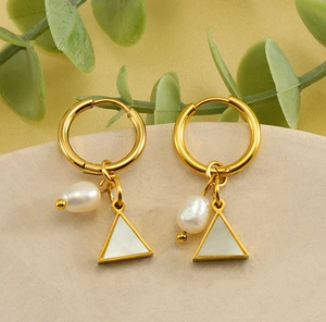 Detail view of gold earrings with white natural pearls and triangular shell charms
