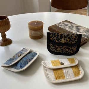Detailed view of canvas mini wallets with leopard, floral, and striped patterns