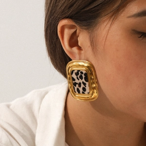 Gros plan professionnel d'une femme portant des boucles d'oreilles léopard en or 18 carats
