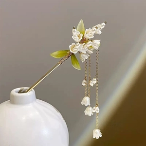 Détail d'épingle à cheveux muguet avec fleurs blanches et glands dorés