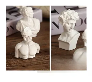 Close-up of white resin mini bust sculpture with detailed David figure on desk