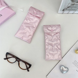 Close-up of pink satin glasses pouches with quilted bow and heart embroidery details