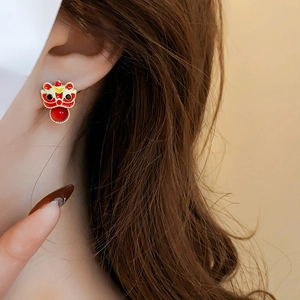 Close-up of traditional lion dance earrings with red beads on a female model