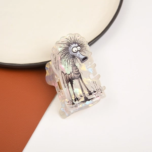 Detailed view of iridescent hair claw clip with dark monster illustration and spring