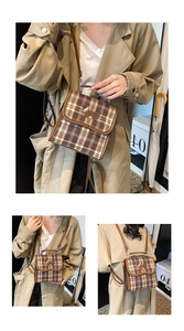 Close-up of vintage brown plaid backpack featuring detailed dog embroidery and handle