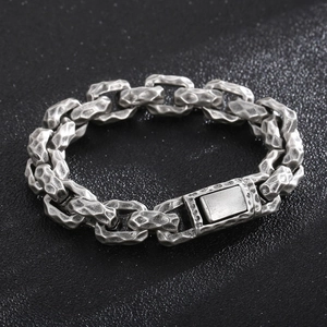 Macro view of vintage silver hammered texture and rectangular clasp on men's steel chain
