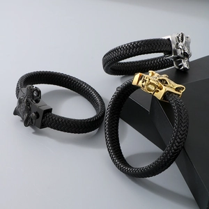 Close-up of wolf head braided leather bracelets in black, silver, and gold steel finishes