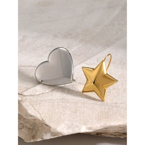 Polished silver heart and gold star earrings on a natural stone background