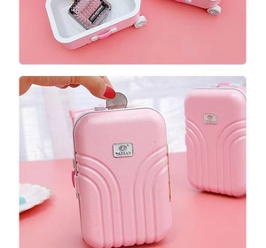 Pink mini suitcase piggy bank with a top coin slot and interior storage for small items