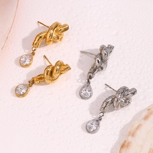 Dettaglio di orecchini a nodo oro e argento con zirconi scintillanti a forma di goccia