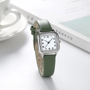 Montre femme carrée élégante avec bracelet en cuir vert et boîtier argenté sur fond stylisé