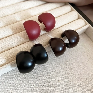 Detailed set of three matte acrylic C-shaped stud earrings in red, brown, and black colors