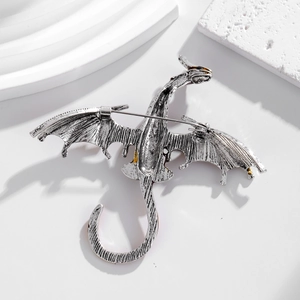 Back view of vintage silver flying dragon brooch with detailed texture and pin clasp