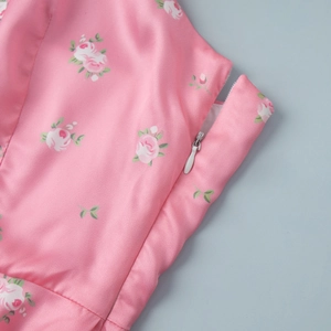 Detail of pink floral satin fabric featuring a high-quality white invisible zipper closure