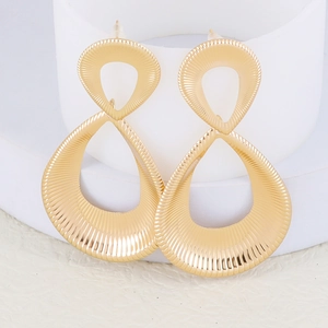 Macro view of gold-tone earrings with double teardrop shape and radial textures