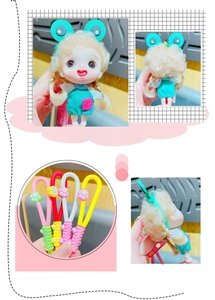 Detail view of a cute cartoon girl doll keychain featuring green frog headwear and PVC strap