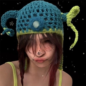 Close-up of chunky knit devil horn beanie in blue and green contrast wool