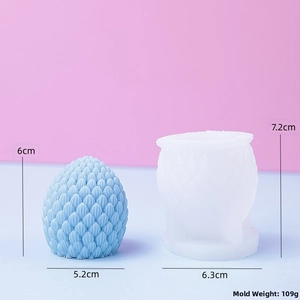 Detailed view of pinecone silicone mold with blue candle showing 3D scale texture