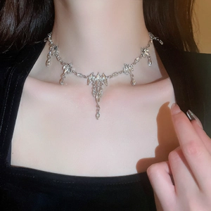 Close-up of elegant silver tassel necklace with rhinestones on a female model