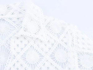 Close-up of the elegant white lace crochet embroidery details and geometric knit patterns