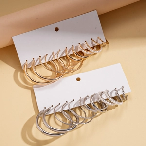 12-piece set of gold and silver hoop earrings with faux pearl accents on white card