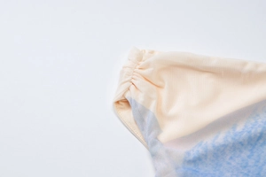 Detailed macro view of beige and blue gradient mesh fabric with elegant ruched edge detail