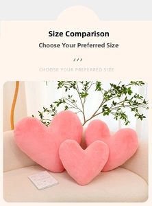 Detailed comparison of three pink plush heart pillows in various sizes on a fabric sofa
