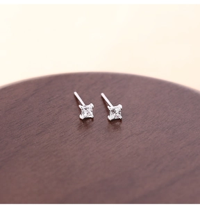 Close-up of minimalist square princess cut cubic zirconia studs on a wooden display