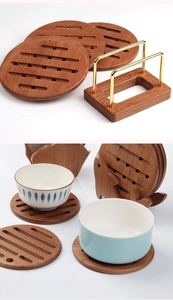 Detail of round walnut wood coasters with hollow design and a gold metal storage rack