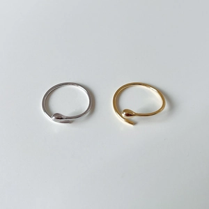 Minimalist silver and gold teardrop open rings in high-polish finish on grey background