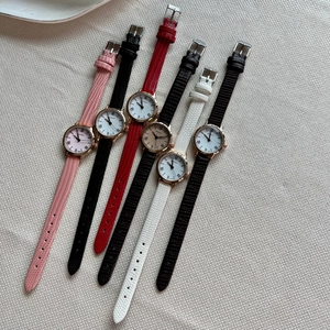 Detailed view of women's watches with small round dials and multi-color leather straps