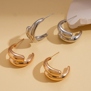 Minimalist metallic C-shape twisted hoop earrings in glossy gold and silver finishes