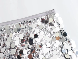 Macro shot of silver sequins on a mini dress showing high-quality sewing and texture