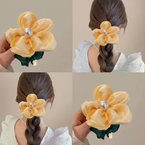 Yellow floral satin hair scrunchie with large faux pearl accent for elegant styling